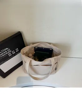 Spacious interior of canvas tote bag showing storage for tablet, umbrella and daily items