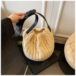 Macro shot of cream woven bucket bag texture with black leather adjustable strap and lining