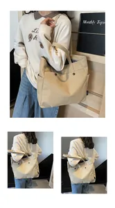 Detail of beige canvas tote bag showing front buckle pocket and spacious side compartments