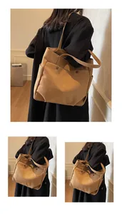 Close-up of khaki canvas tote bag showing side pocket and dual strap construction details