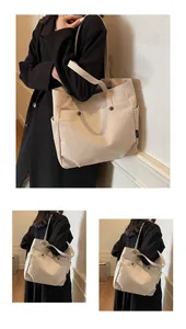 Detail view of cream canvas tote bag showing side pockets and brown decorative buttons