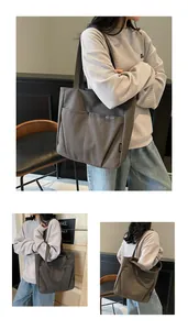 Detail view of large canvas tote bag showing dual front pockets and durable fabric texture