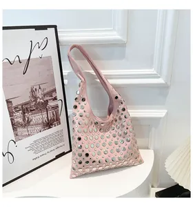 Close-up of pink rivet shoulder bag with silver studs on white display stand