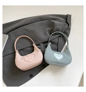 Detailansicht der hellrosa und blauen herzförmigen Mini-Taschen mit Lederstruktur und Herzdekor