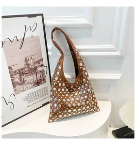 Detailed close-up of brown PU leather bag with silver rivet studs and geometric design
