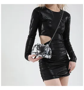 Detail einer transparenten PVC-Minitasche mit Zebramuster, gehalten von einem Modell