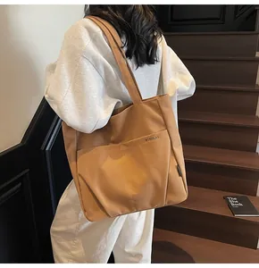 Detailed view of dark brown canvas tote bag with front pocket and shoulder strap design