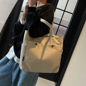 Minimalist beige canvas tote bag with brown buttons and large front pocket for women
