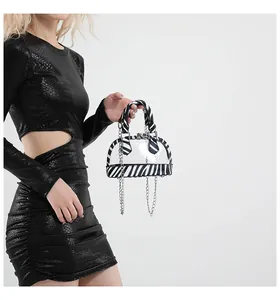 Details der Zebra-Print-Nähte an transparenter PVC-Handtasche mit metallischer Kette