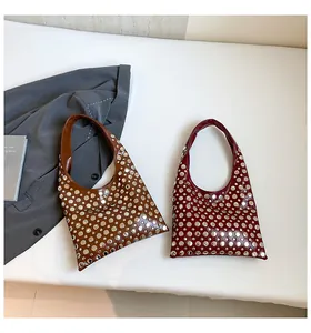 Detail of studded dark coffee and wine red leather hobo bags with metallic rivets