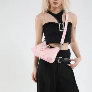 Sac demi-lune en cuir verni rose avec bandoulière cloutée et détails argentés