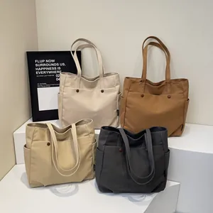 Minimalist canvas tote bag with dual front pockets in beige, brown, khaki, and dark gray