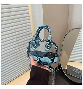 Detail der transparenten PVC-Minotasche mit blauem Schlangenmuster und silberner Kette