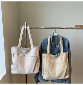 Detailed close-up of durable canvas tote bags featuring front pockets and premium stitching