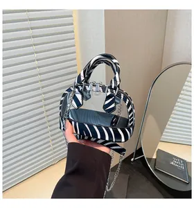 Detail der PVC-Minitausche mit Zebra-Print, transparentem Panel und Silberkette