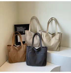 Detail of four colorful canvas tote bags with front pockets and shoulder straps