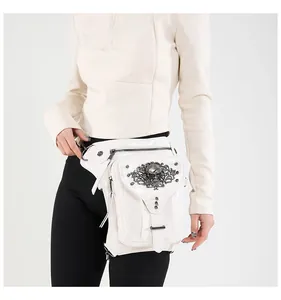 Détail du sac banane punk blanc avec emblème de crâne en métal et rivets sur cuir verni