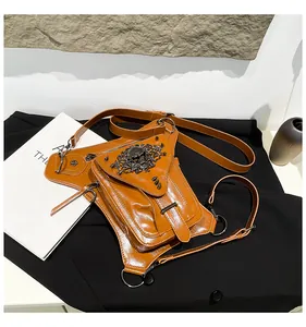 Détail du sac de taille punk marron avec relief de crâne et clous noirs pointus