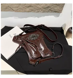 Détail de la sacoche punk avec emblème de crâne argenté et rivets métalliques