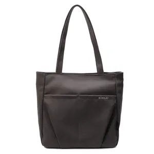 Classic dark canvas tote bag with long handles and white lettering logo on a white background