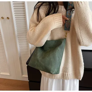 Detail of dark green matte tote bag featuring a vintage ethnic pattern woven wide strap