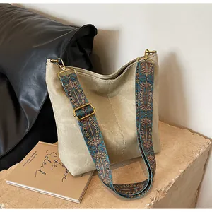 Detail of vintage bucket bag featuring a wide ethnic patterned woven shoulder strap