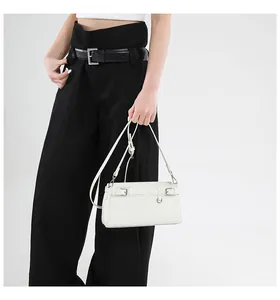 Modell mit weißer Leder-Schultertasche, verzierten Schnallen und Silber-Beschlägen