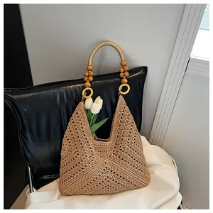 Detailed close-up of woven hobo bag featuring ornate wooden bead handle and floral texture