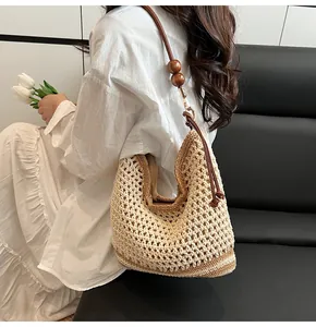 Close-up of bohemian crochet tote with hollow-out knit pattern and wooden bead strap detail