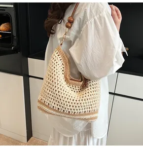 Detail of hollow knit tote bag with wooden bead accents and bohemian mesh texture