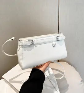 Detail der cremeweißen PU-Lederhandtasche mit silbernen Schnallen und verstellbarem Gurt
