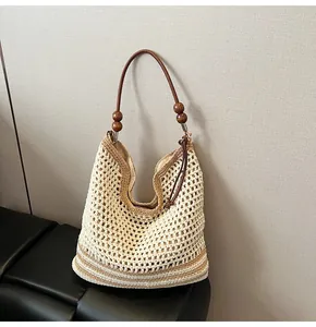 Close-up of bohemian woven tote bag showing hollow crochet texture and wooden bead accents