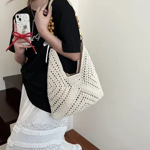 White handwoven crochet shoulder bag with yellow wooden bead handle and geometric pattern