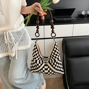 Handcrafted crochet shoulder bag with black and white geometric pattern and wooden bead handle