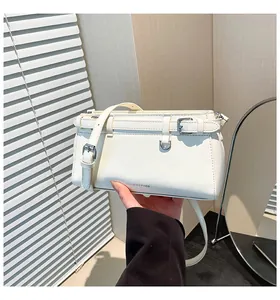 Detailansicht der weißen Lederhandtasche mit silberner Gürtelschnalle und Logo-Prägung