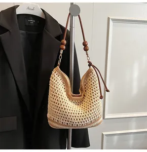 Detail of hand-woven crochet tote with mesh texture and round wooden beads on strap