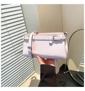 Detailaufnahme der hellrosa Ledertasche mit dekorativem Gürtelschnallen-Design und Textur