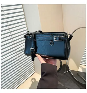 Detailansicht der schwarzen Schultertasche aus Leder mit dekorativen silbernen Gürtelschnallen
