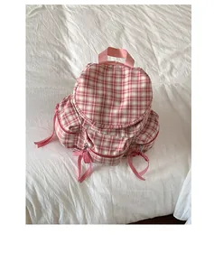 Détail du sac à dos en toile vichy rose avec ruban décoratif et poches multiples