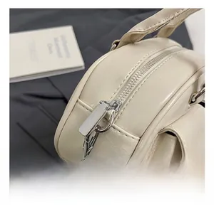 Detailed close-up of premium silver zipper and hardware on cream underarm bag