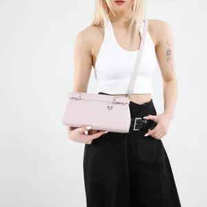 Minimalistische hellrosa Umhängetasche mit Silberschnallen am Modell im Studio