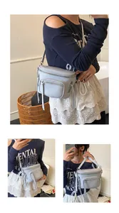 Détails du sac selle bleu clair avec fermetures éclair à pompons et bandoulière réglable