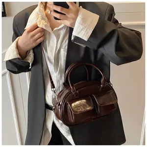 Polished brown patent leather handbag with dual front pockets shown on model