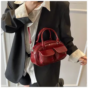 Detail of a vintage dark red glossy bowling bag showing functional front pockets and straps