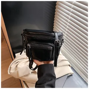 Gros plan sur un sac selle en similicuir noir avec fermetures éclair argentées