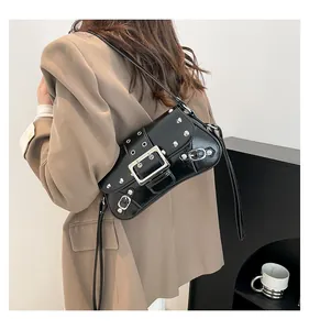Détail du sac à bandoulière punk noir avec rivets et boucles argentés porté par un modèle
