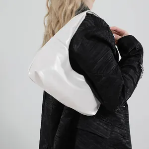 Glänzende weiße halbmondförmige Hobo-Tasche mit Nieten-Detail am Model im Studio-Stil
