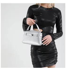 Detailed close-up of metallic silver handbag with premium textured surface and metal buckle
