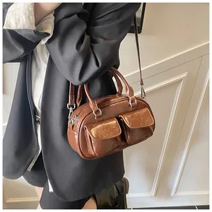 Macro detail of glossy dark brown pillow bag featuring double front flap pockets