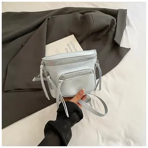 Détail du sac selle bleu clair avec double fermeture éclair et cuir synthétique lisse